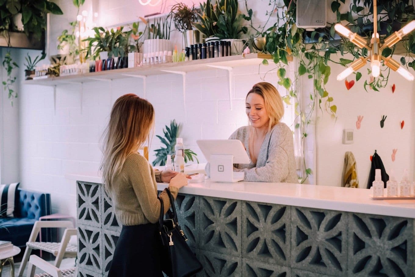 Twee medewerkers helpen een gast bij de balie